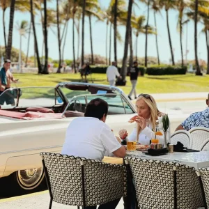 Convertible parked on Ocean Drive beside the palm-lined stretch near Montana's Miami Beach.
