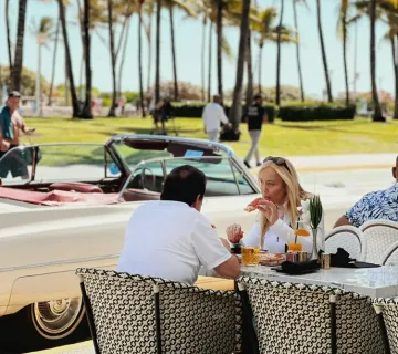 Convertible parked on Ocean Drive beside the palm-lined stretch near Montana's Miami Beach.