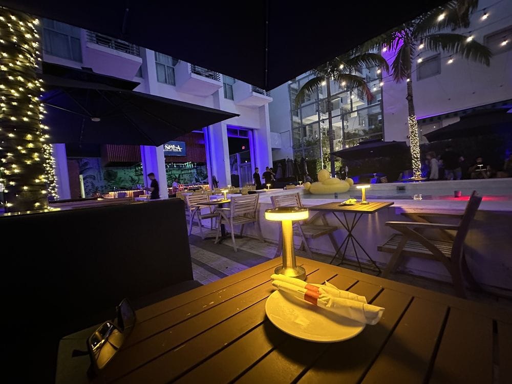 o-2 Candlelit rooftop lounge table with folded napkins at a Miami Beach venue at night