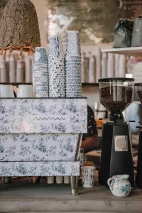 Blue patterned coffee cups and floral espresso machine on the Maman Miami Beach cafe counter.