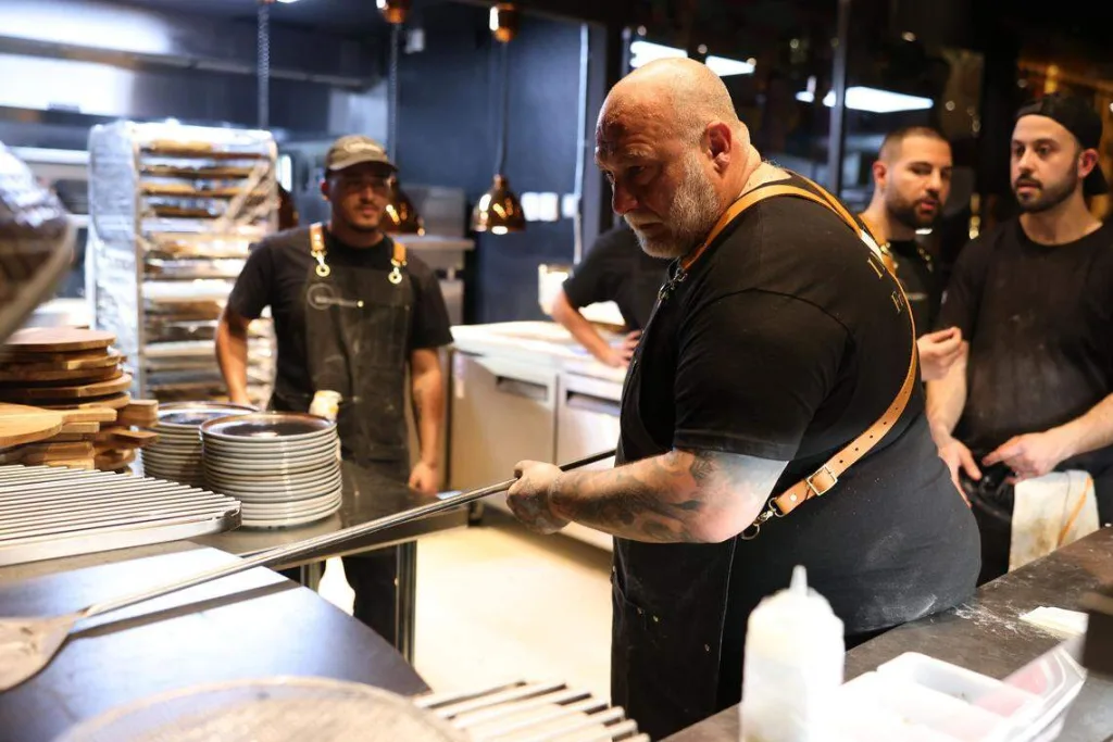 Francesco Martucci cooking pizza alongside his team in the Wynwood kitchen