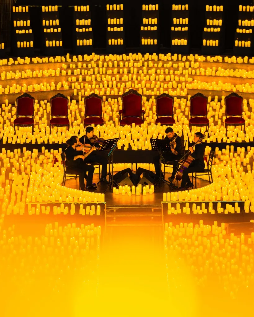 Candlelight concert stage surrounded by hundreds of candles with live musicians performing.