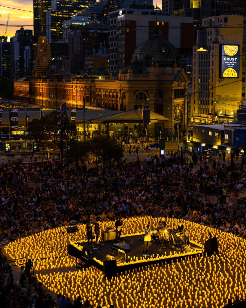 Audience enjoying a Candlelight concert with musicians performing and candles lighting the room