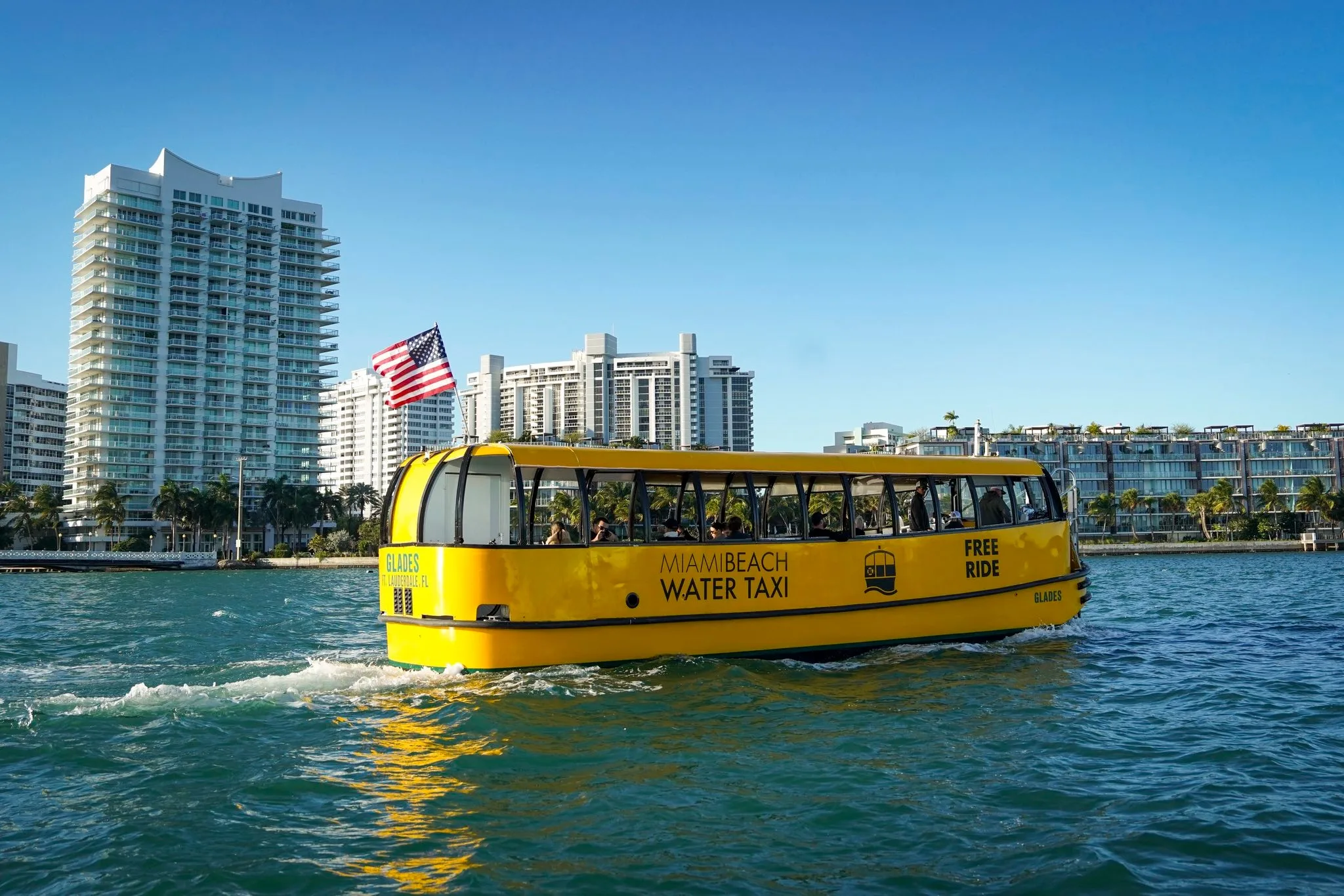 miami-beach-taxi Miami Beach waterfront with water taxi cruising under clear blue skies