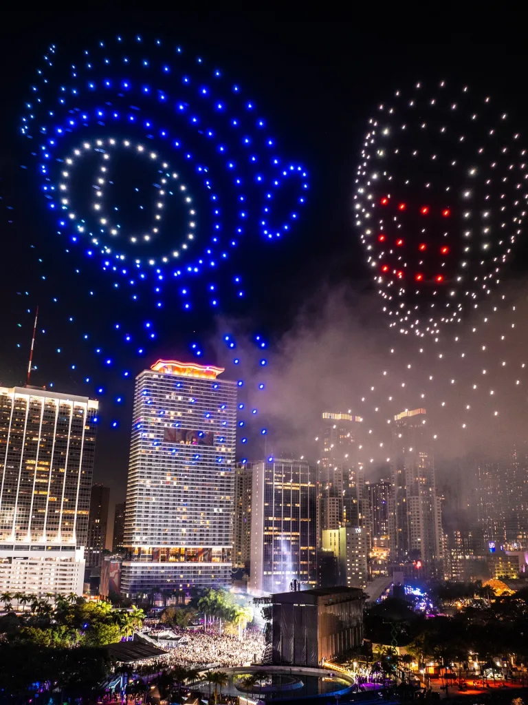 Drone light show forming shapes above Bayfront Park with Miami skyline in the background