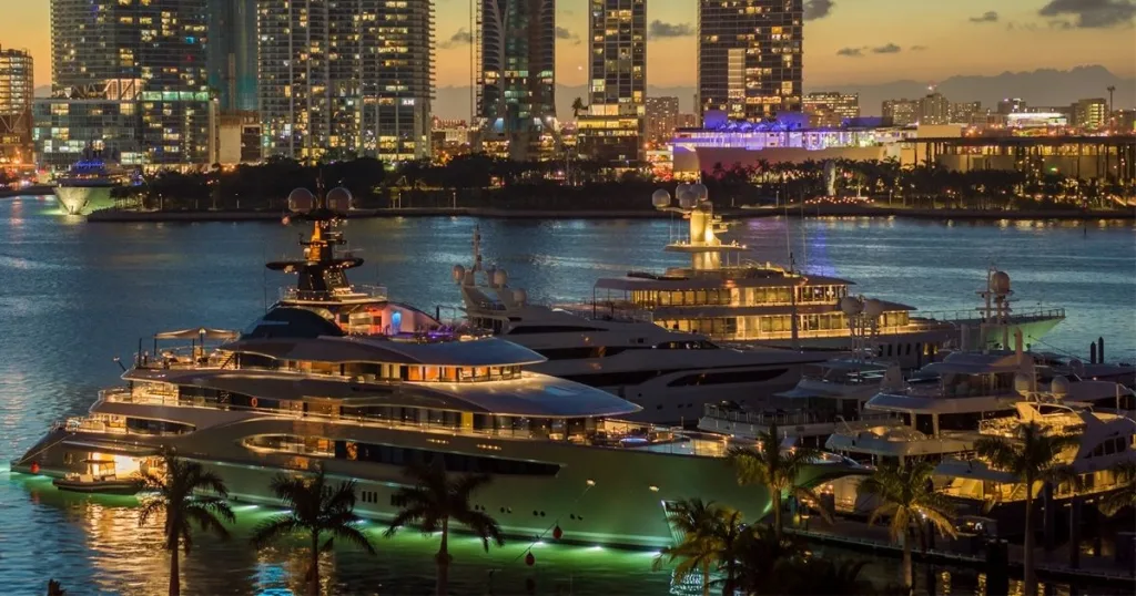Ultra-luxury superyacht at the Miami Boat Show, featuring a sleek modern profile, glossy white finish, and upscale marina backdrop