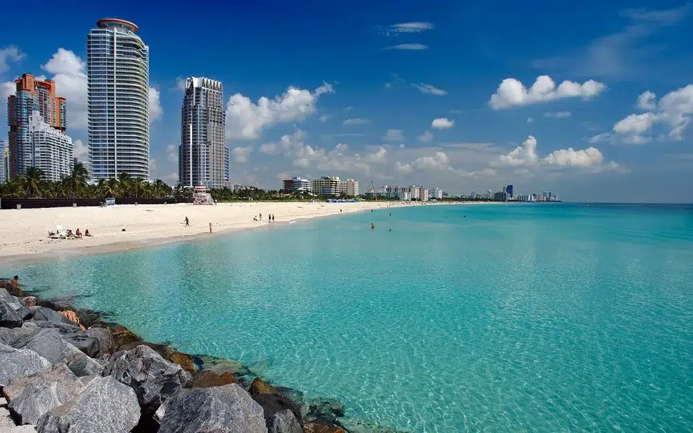 Close-up of gentle waves rolling onto the sand at South Beach with sun glitter on the sea.
