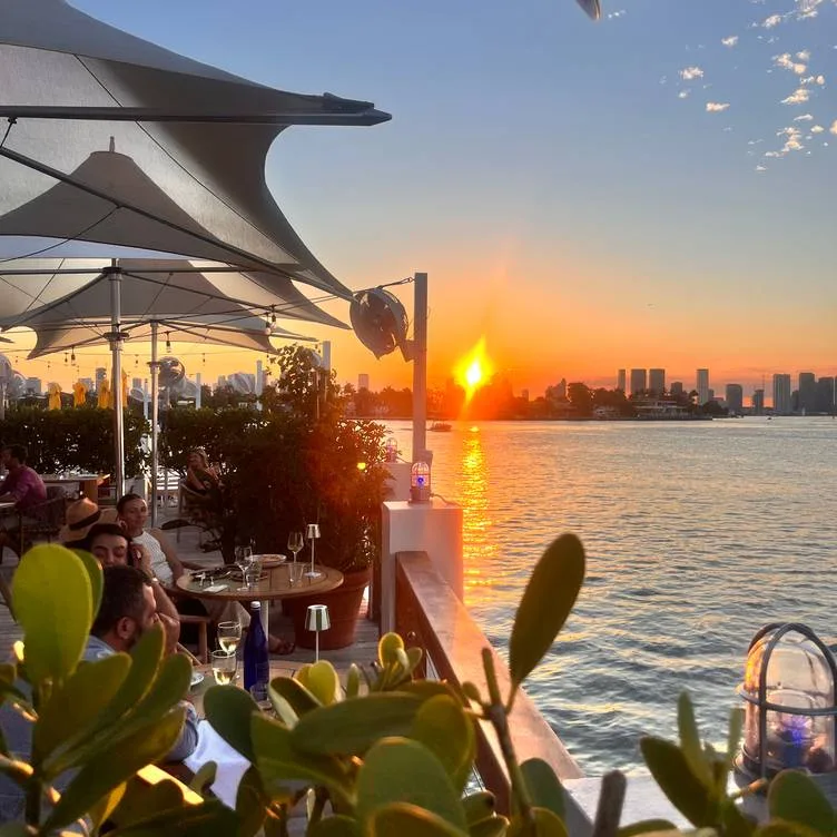 Sunset waterfront happy hour at Lido Bayside Grill terrace overlooking Biscayne Bay in Miami Beach