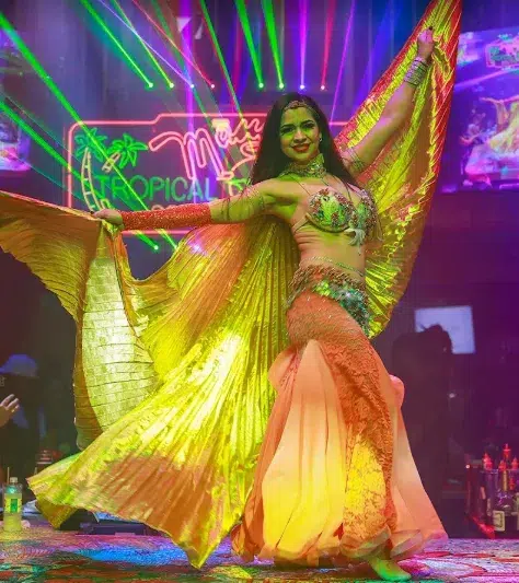 Energetic dancer performing at Mango’s Tropical Cafe surrounded by bright lights and party vibes