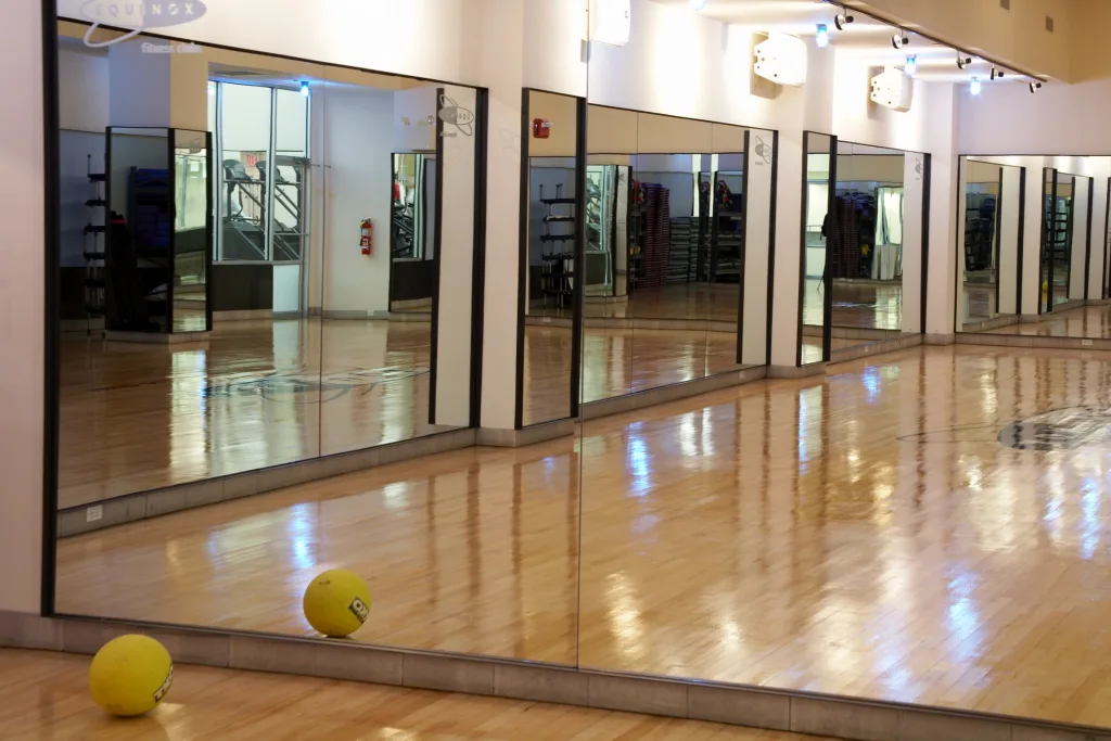 Group fitness studio with mirrored walls and wooden floor at Equinox South Beach Miami Beach