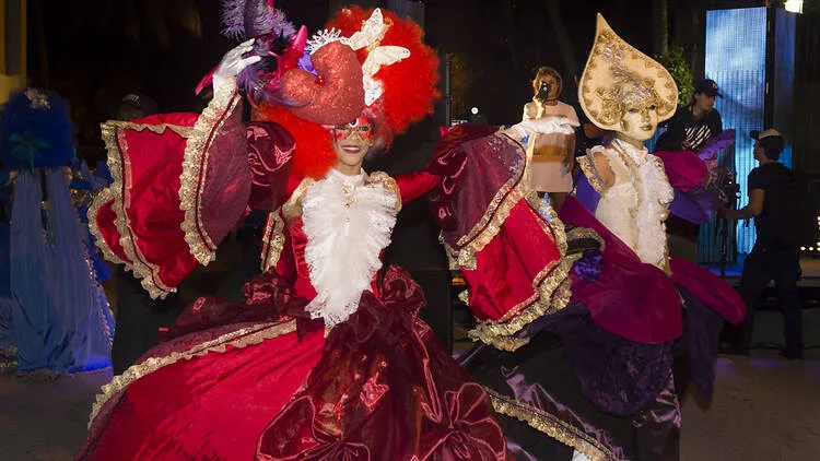 Venetian carnival dancers in red costumes performing during an Easter celebration event in Miami Beach