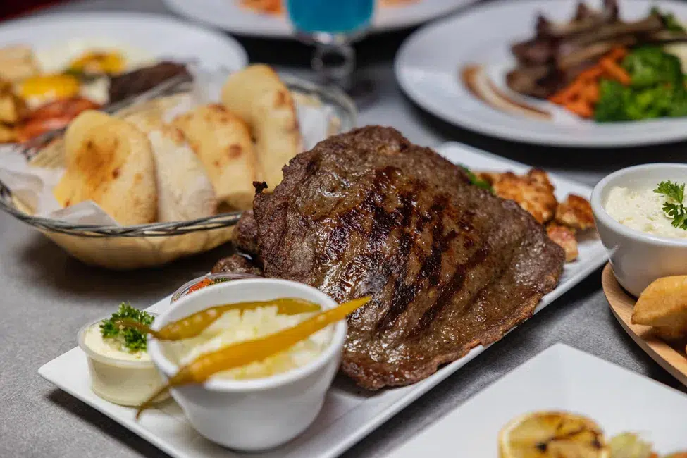 Premium grilled steak with Balkan side dishes and fresh bread served at Rakija Lounge Miami Beach