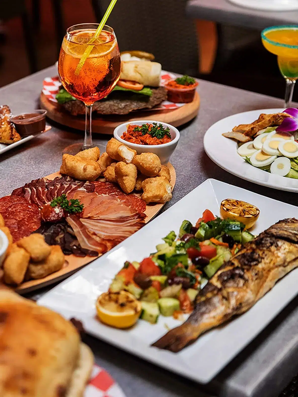 Authentic Balkan food platter with grilled fish, appetizers, and cocktails at Rakija Lounge Miami Beach