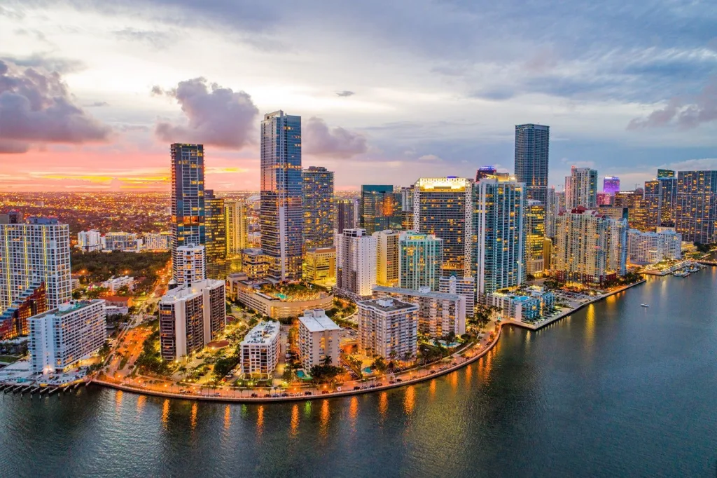 Miami skyline glowing at night with city lights and waterfront views