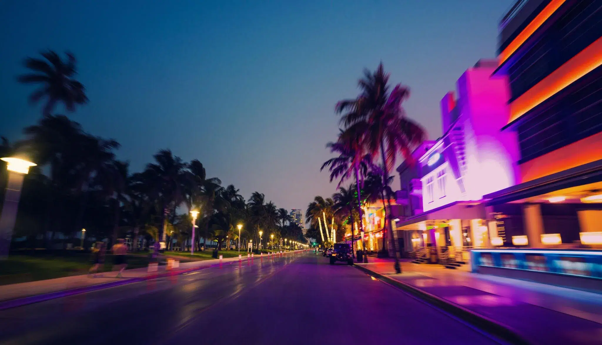Ocean Drive Miami Beach at night with neon lights, palm trees, and vibrant nightlife scene