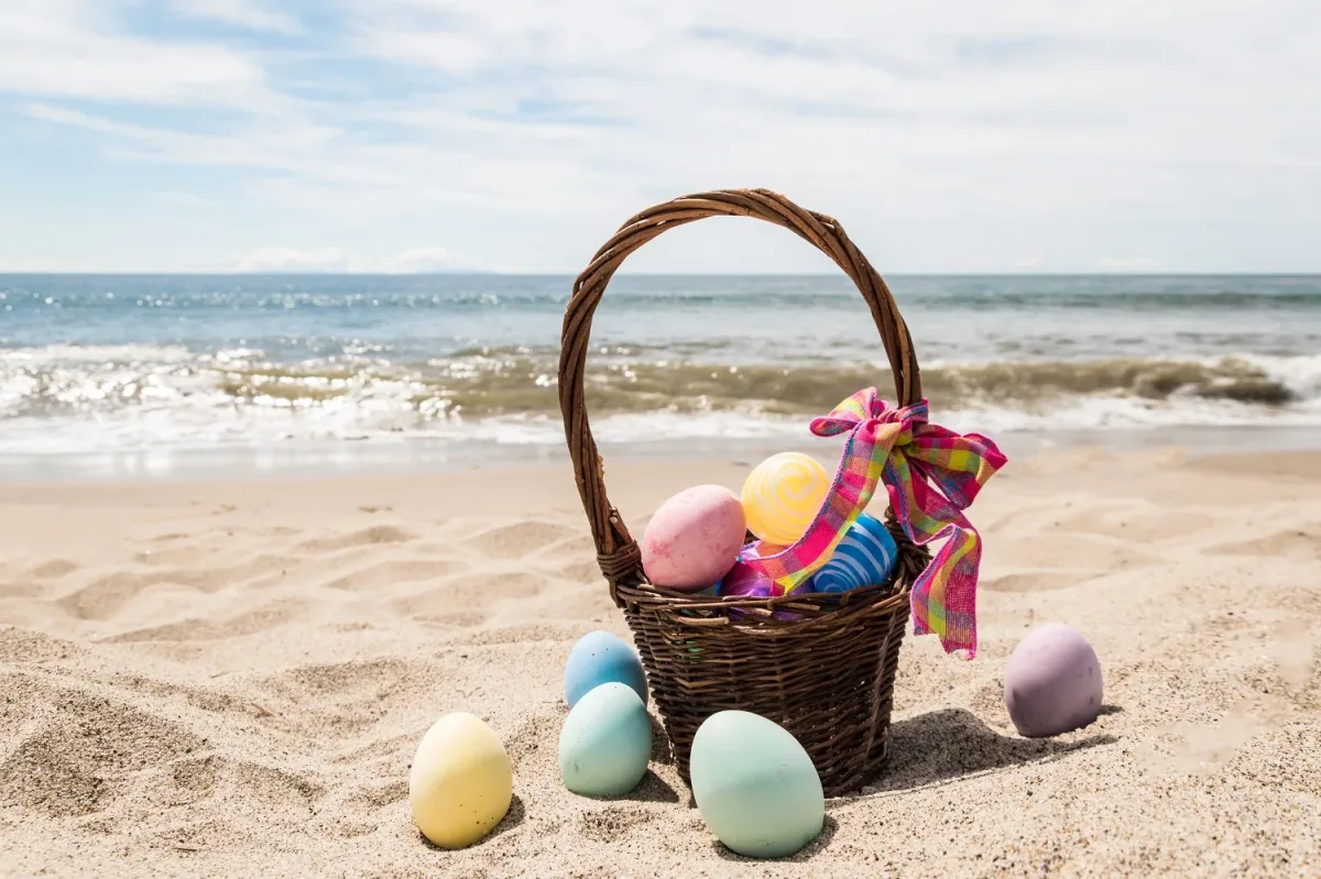 Easter Basket with Colorful Eggs on Miami Beach Shore Colorful Easter eggs in a basket on the sandy beach with ocean waves in Miami Beach