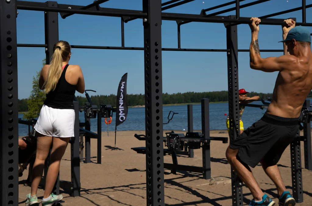 People doing pull-ups and bodyweight exercises at Muscle Beach outdoor gym in Miami Beach