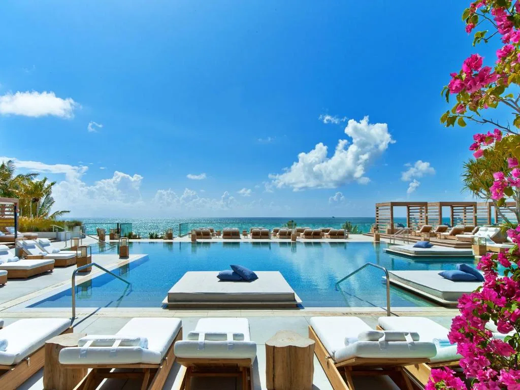 Luxury pool deck at 1 Hotel South Beach with palms and ocean views