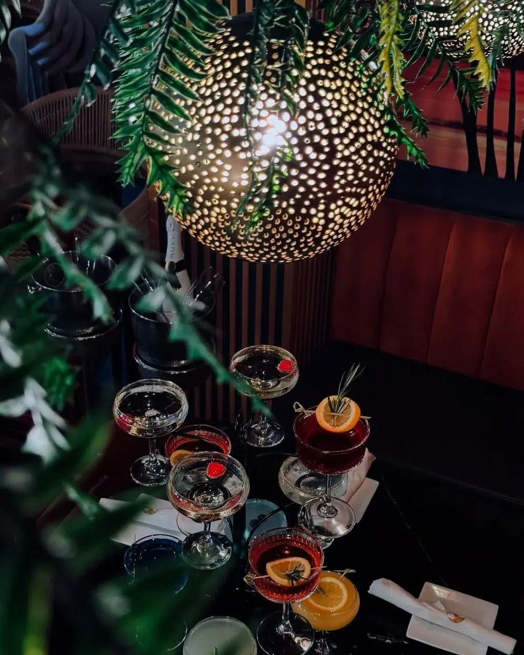 Elegant cocktail presentation inside a Miami lounge featuring crafted drinks, moody lighting, tropical décor, and an upscale nightlife ambiance.