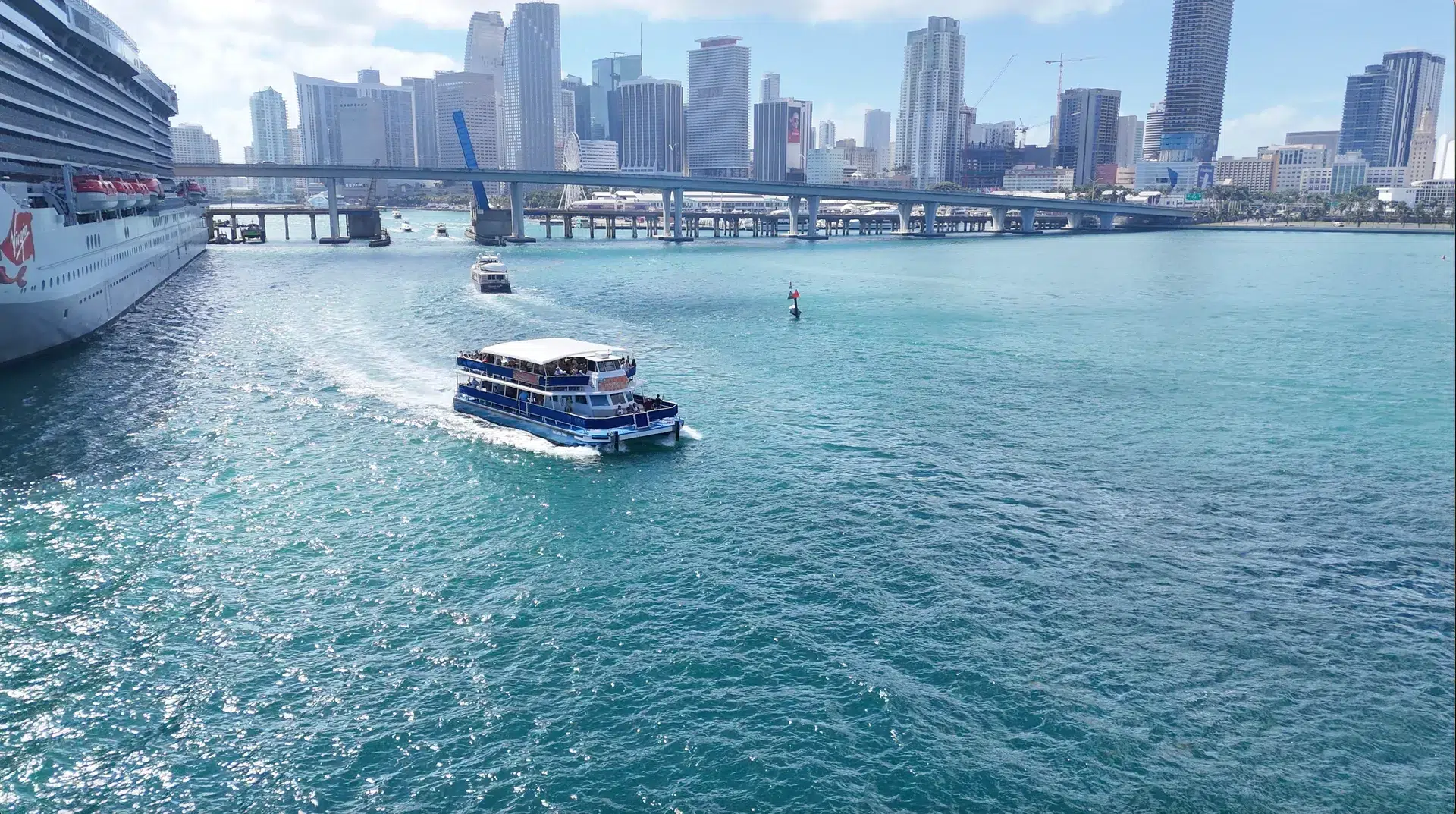 Boat cruising through Biscayne Bay with the Miami skyline and downtown bridges in the background during Memorial Day Weekend in Miami.