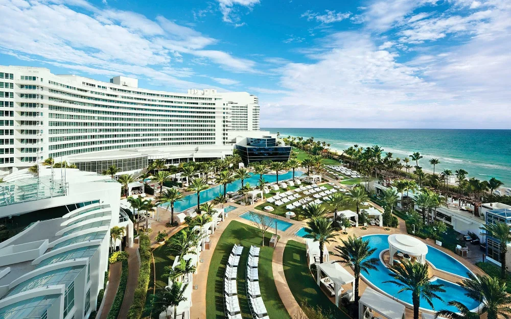 Miami Beach coastline with turquoise water, palm trees, and beachfront hotels