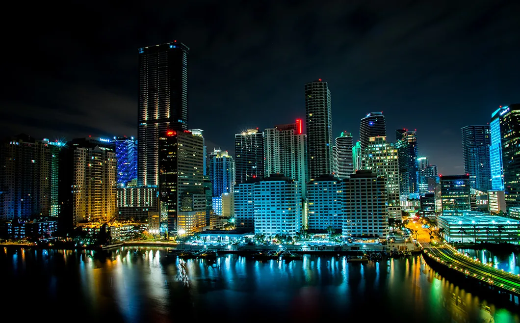 miami-nightlife Miami skyline at night with illuminated buildings and city lights over the water