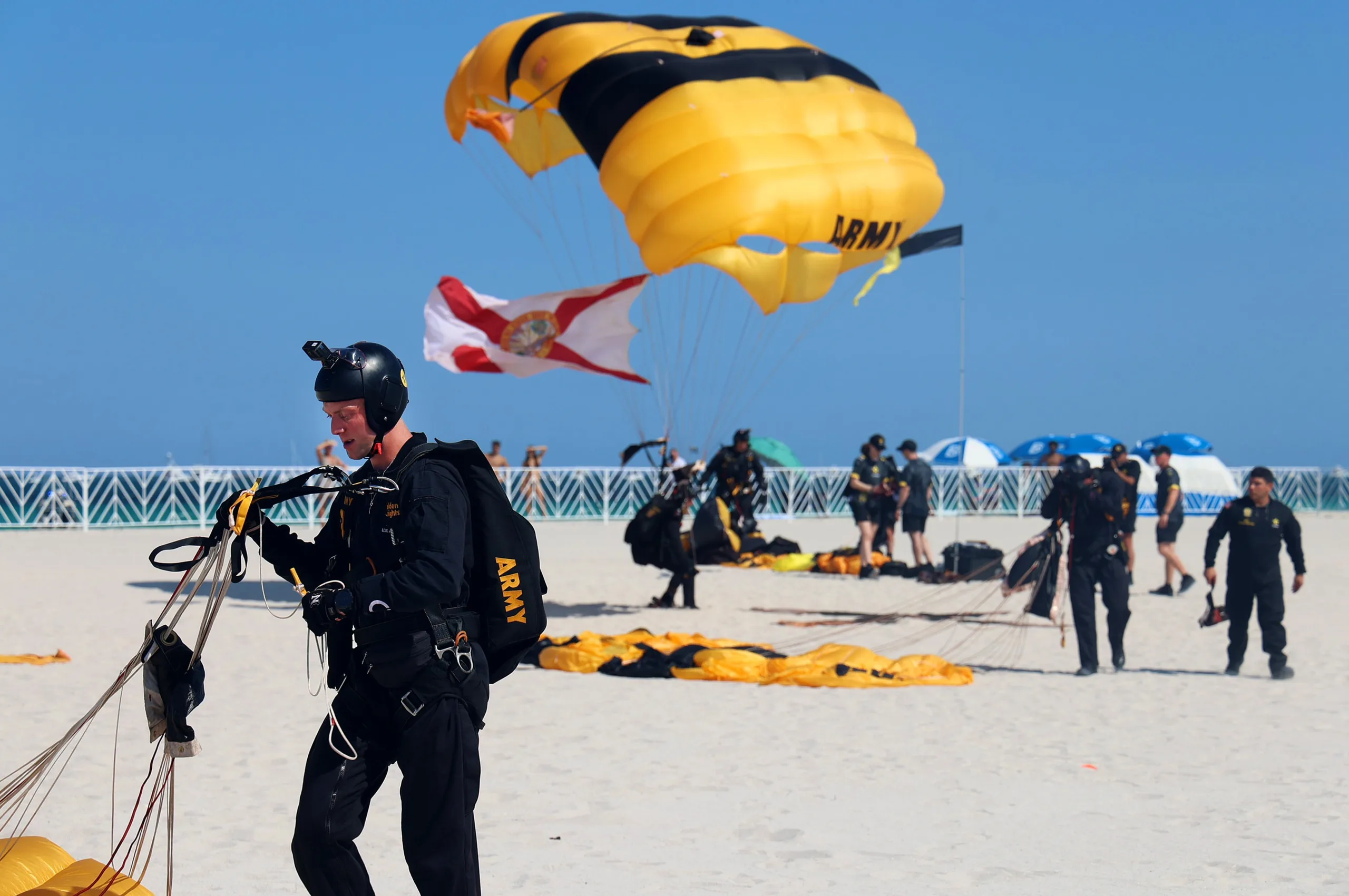 Army parachute team landing on Miami Beach during a live military skydiving demonstration for Memorial Day Weekend celebrations.