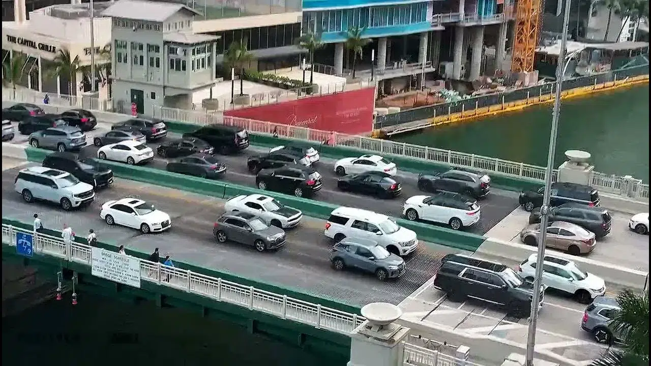 Traffic backed up on the Brickell Avenue Bridge in Downtown Miami with multiple vehicles waiting during heavy congestion near the waterfront.