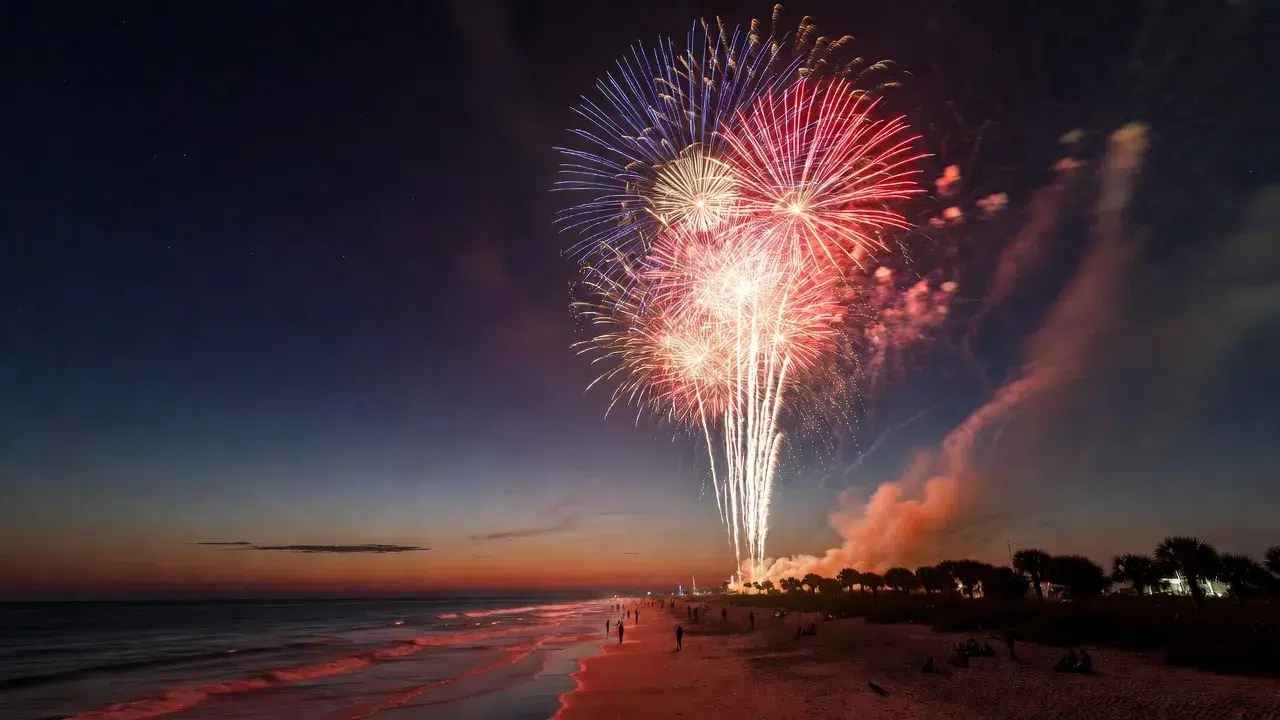 Fourth of July fireworks illuminate the Miami Beach shoreline at sunset, creating a spectacular Independence Day celebration along the Atlantic coast.