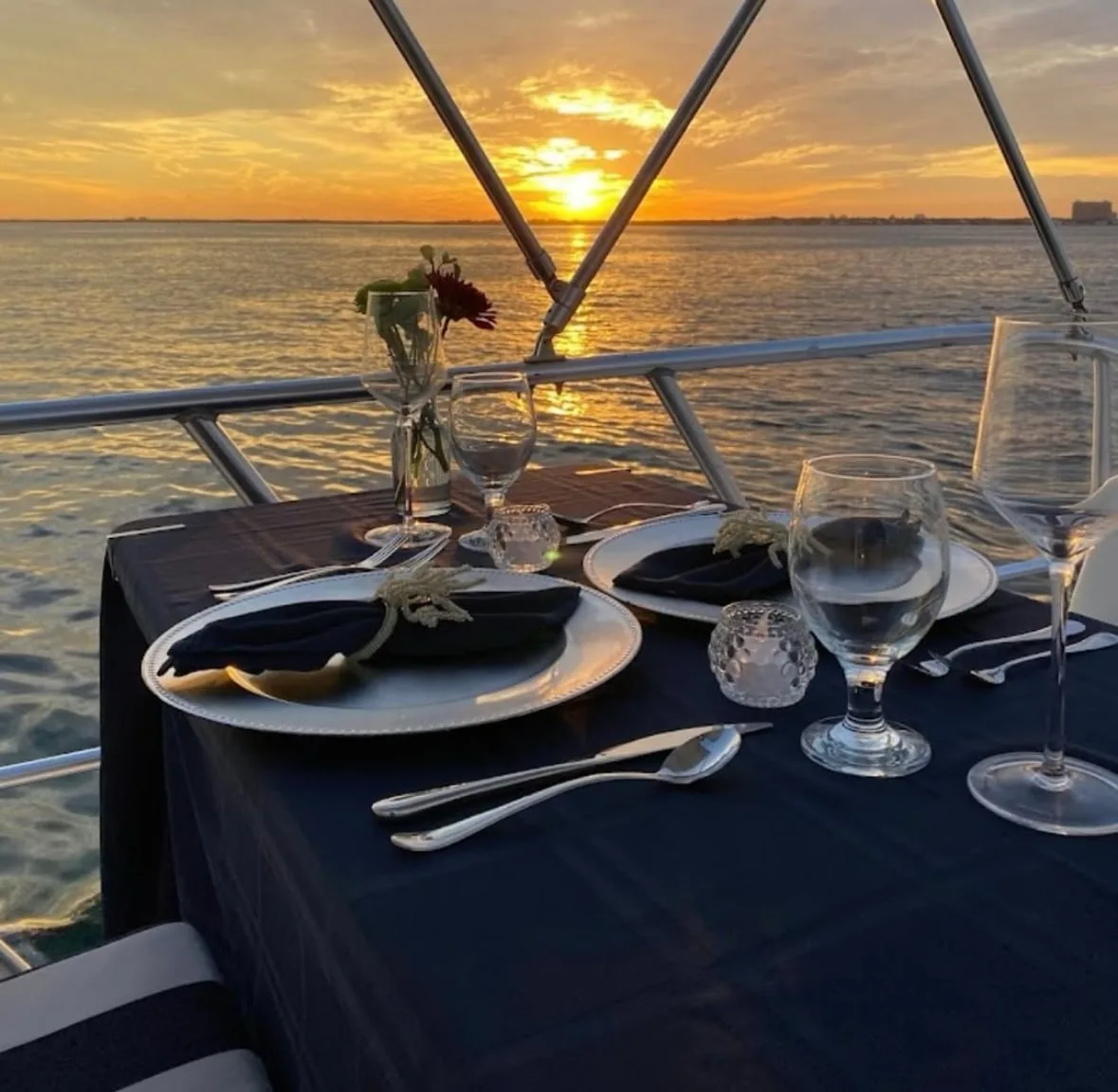 Elegant sunset dinner setup aboard a boat in Biscayne Bay with waterfront views, creating a memorable Father's Day dining experience in Miami.
