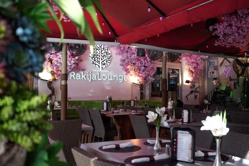 Outdoor dining area at Rakija Lounge Miami Beach featuring floral décor, ambient lighting, comfortable seating, and a vibrant atmosphere for dining, cocktails, and nightlife experiences.