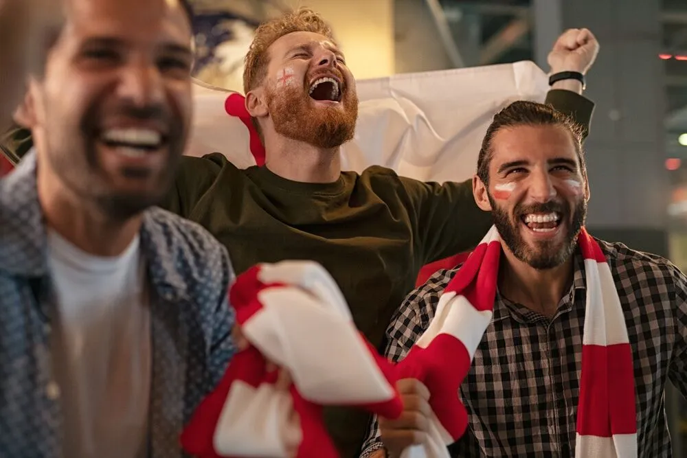 Soccer fans celebrating together while watching a FIFA World Cup match in Miami, creating an energetic atmosphere filled with team pride and excitement.