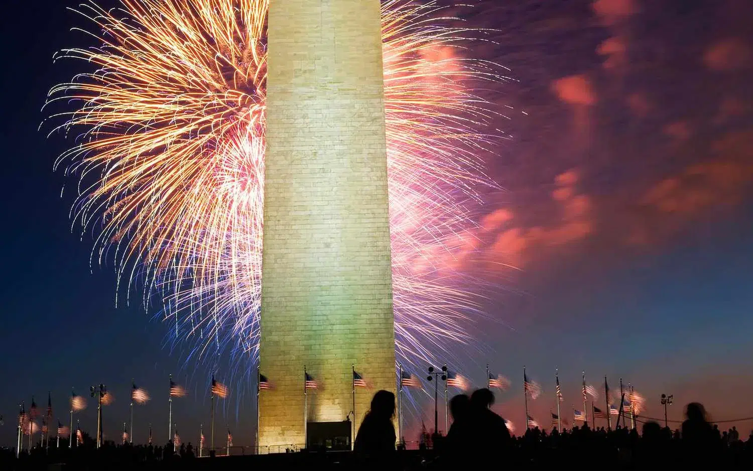 Fireworks light up the sky behind the Washington Monument during a Fourth of July celebration, symbolizing America's Independence Day and patriotic traditions.