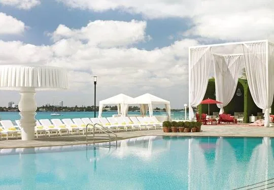 Elegant poolside cabanas overlooking Biscayne Bay at a Miami waterfront venue, creating a stylish atmosphere for Bastille Day festivities, cocktails, and sunset gatherings.