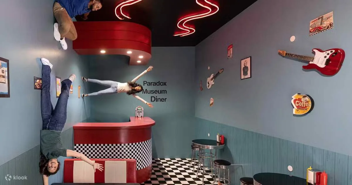 Visitors exploring a gravity-defying illusion room at Paradox Museum Miami, featuring upside-down furniture and interactive exhibits that create mind-bending photo opportunities.