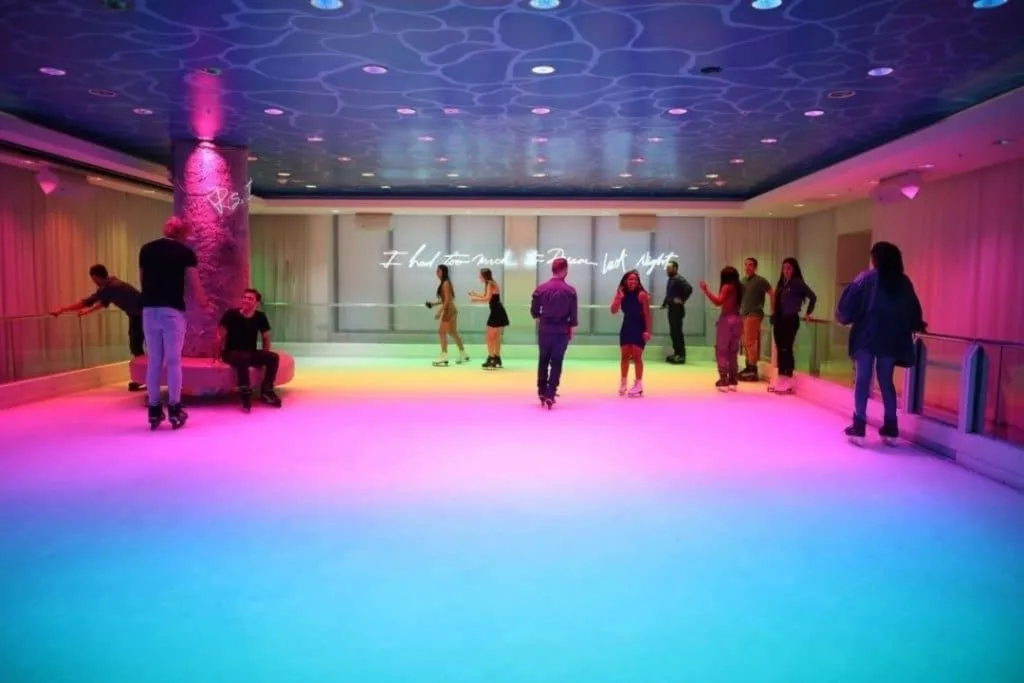 Visitors enjoying the indoor ice-skating rink at Basement Miami, featuring vibrant lighting and a fun, air-conditioned escape from Miami's summer heat.