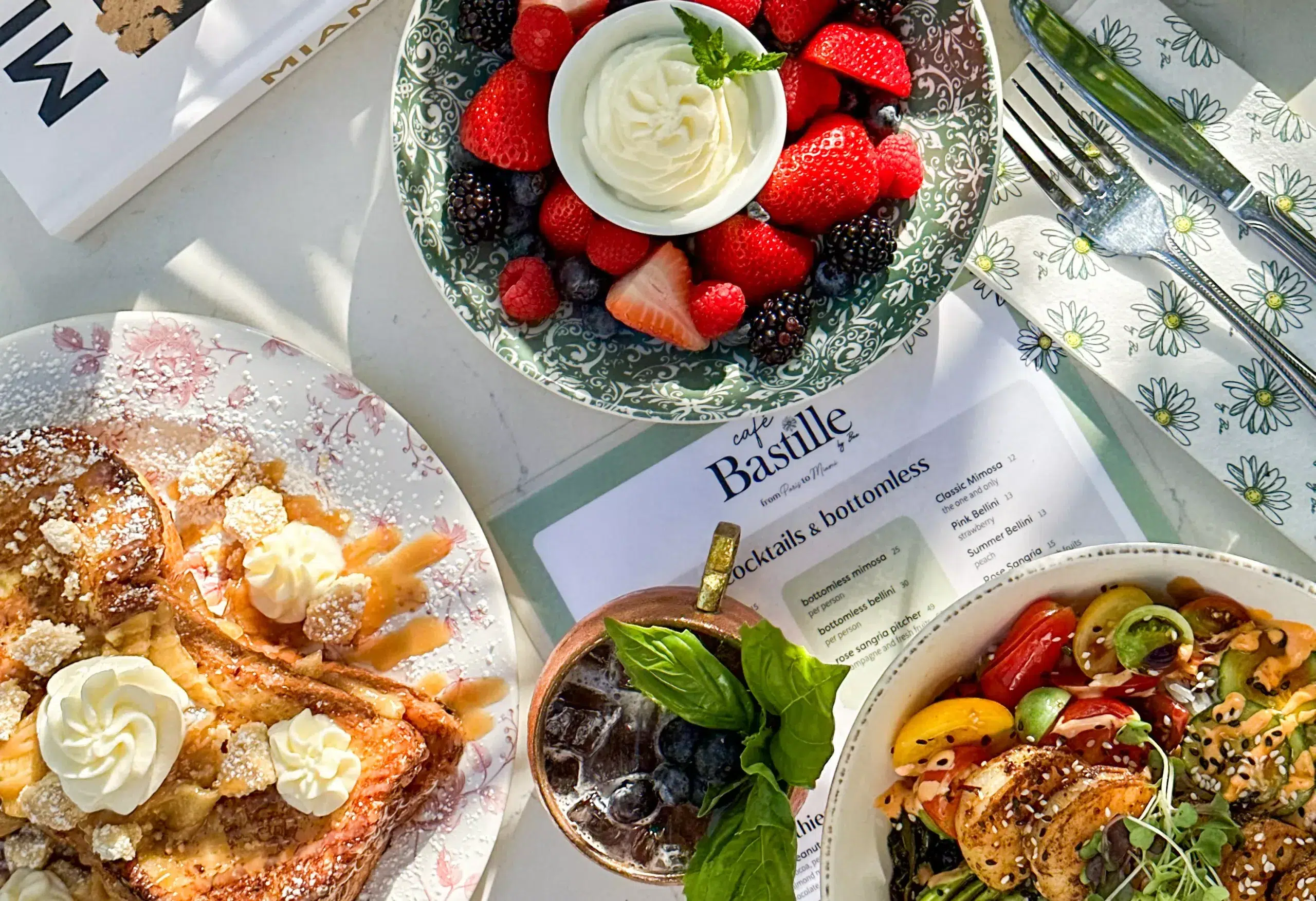 French-inspired brunch featuring pastries, fresh berries, whipped cream, and Mediterranean dishes, showcasing Bastille Day dining specials at a Miami restaurant.